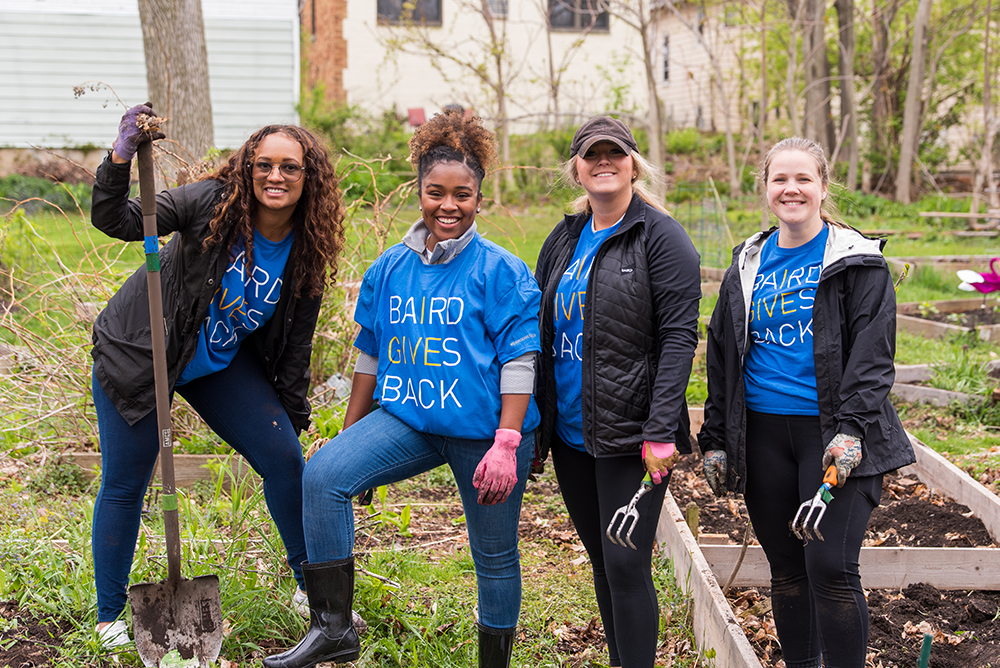 Four Liberty associates working in an outdoor garden while volunteering.