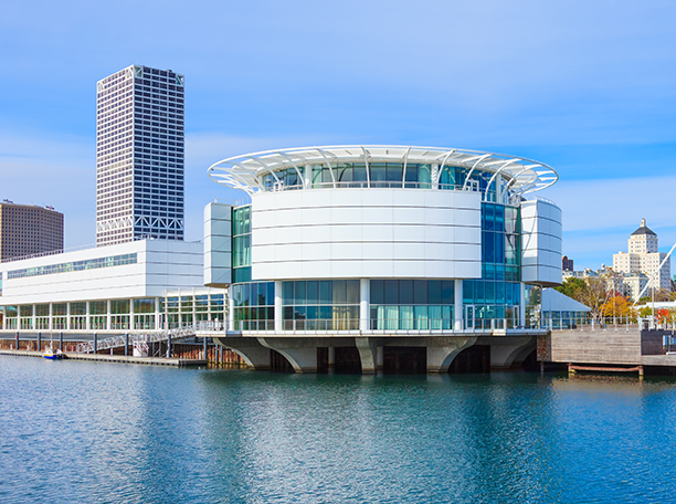 Discovery World’s circular building on Milwaukee’s lakefront with Liberty office building rising in the background.